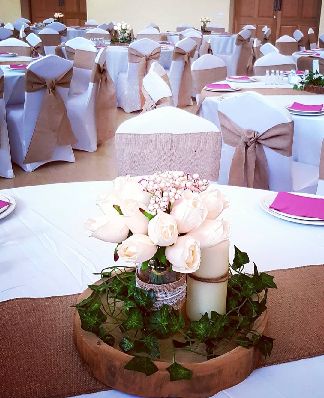 Round tables with chair covers and centrepieces set up for a celebration