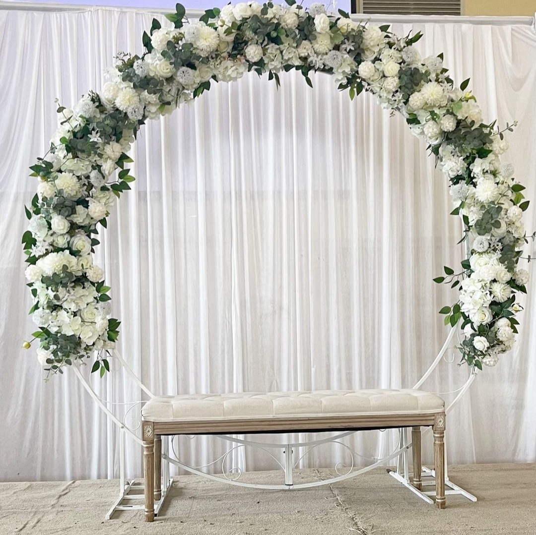White floral arch with seating arranged for a ceremony